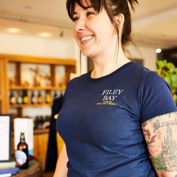 Filey Bay T-Shirt, modelled by Amy in the Distillery Shop, with a big smile!